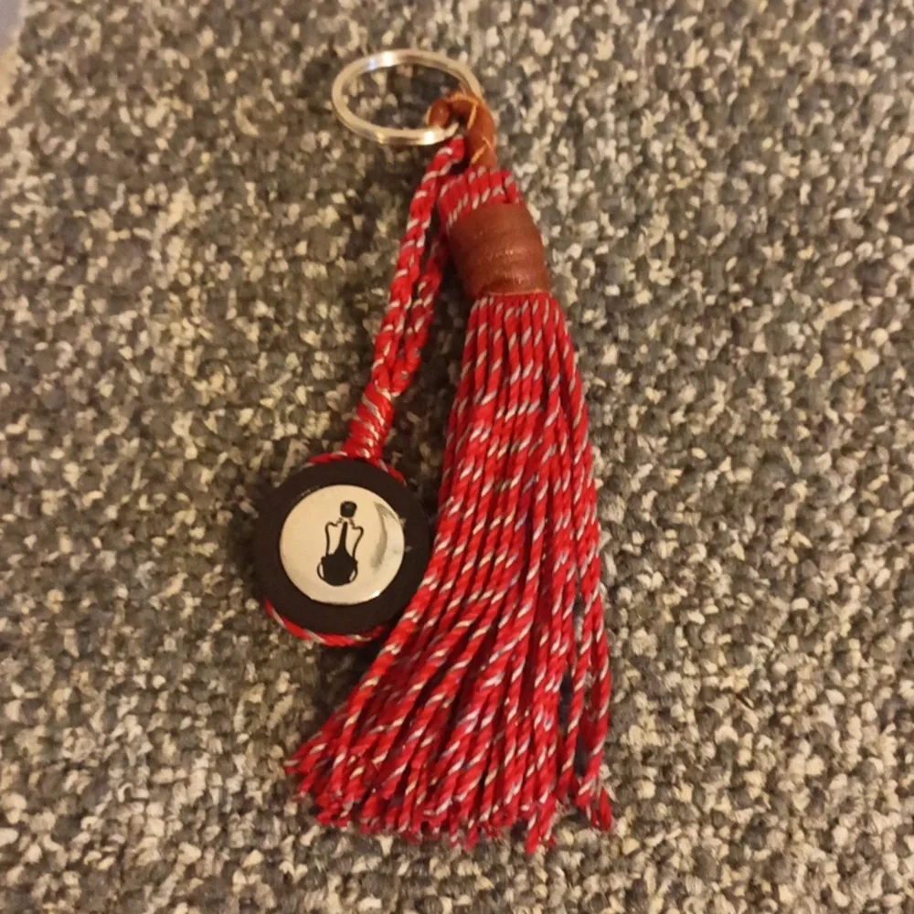 The Sak red and brown leather keychain the Sak emblem